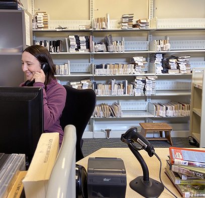 Outreach library staff member taking a phone call.