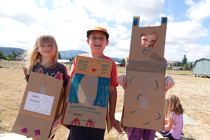 Three kids wearing costumes made at the Cardboard Kingdom program in Sequim.