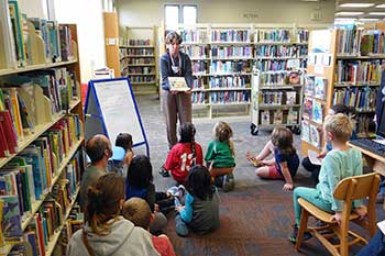 Librarian reading a book to children in the Sequim Library.