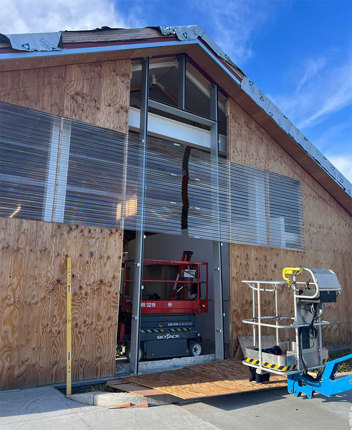 Temporary wall materials are being removed to allow for the installation of framing and windows on the east wall of the Sequim Library on December 22, following the arrival of specially fabricated materials.